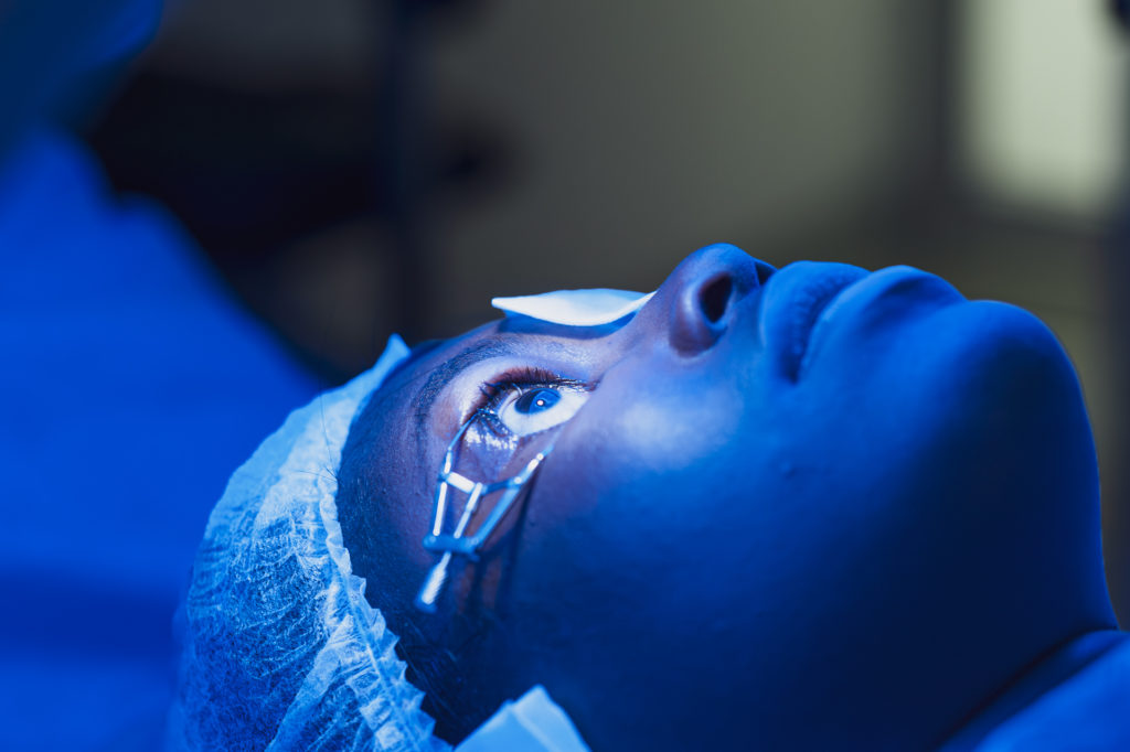 Patiente noire sous une une lumiere bleue pendant une opération chirurgicale de l'oeil