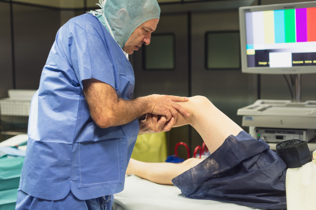 Chirurgien orthopédique tenant la jambe d'un patient avant l'operation